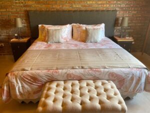 Visa de la cama Queen de la habitación de la cabaña La pequeña perteneciente a One Cabañas en Los Antiguos