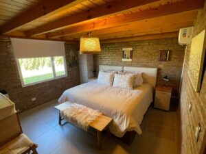vista de la cama matrimonial en dormitorio de la cabaña Mani en One Cabañas, Los Antiguos, Santa Cruz