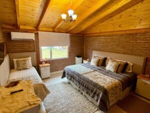 Vista de la cama de la habitación de la cabaña Mirador perteneciente a One Cabañas, alojamiento en Los Antiguos, Santa Cruz